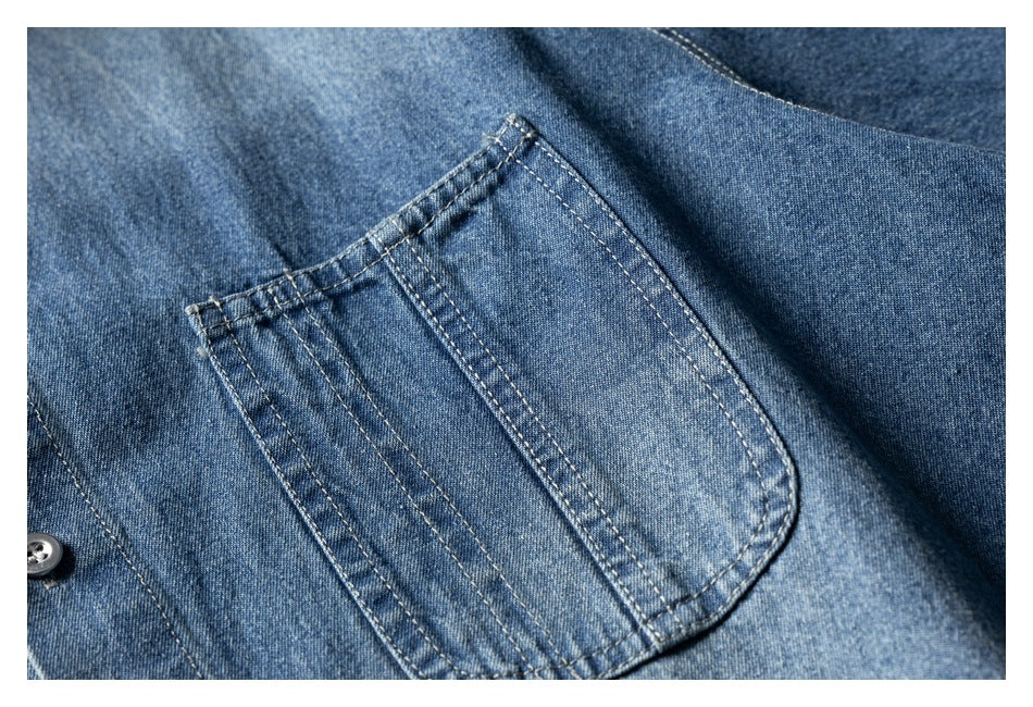 Close-up of a blue denim shirt chest pocket and contrast stitching.