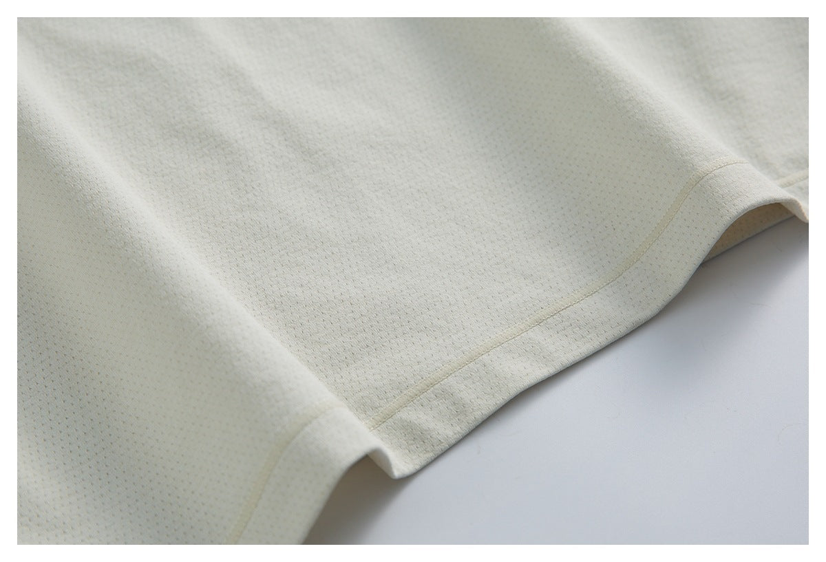 Close-up of the ivory top's perforated fabric and stitched hem.