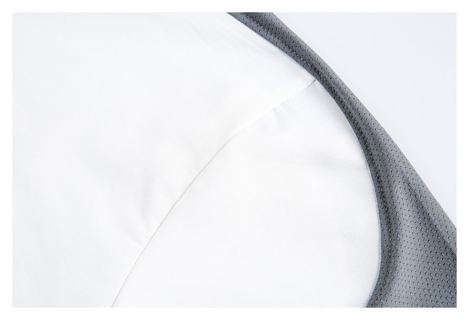 Close-up of white garment fabric with a curved seam beside gray perforated mesh trim.