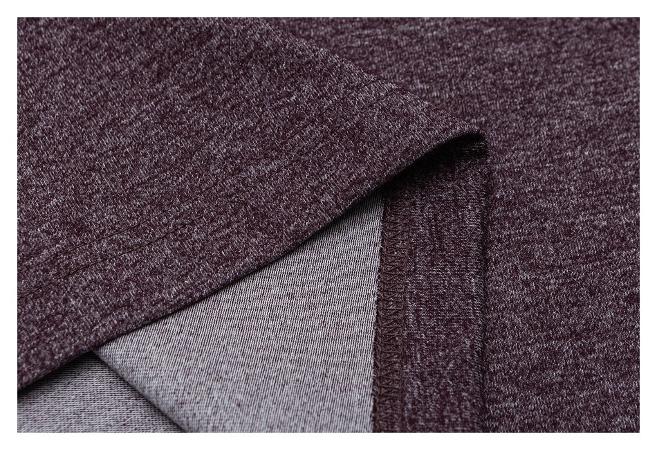 Close-up of a folded burgundy heathered shirt edge showing pale gray reverse fabric and stitched seam.