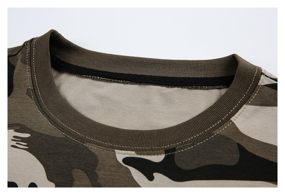 Close-up of the ribbed brown crew neckline and stitching on a tan camouflage T-shirt.