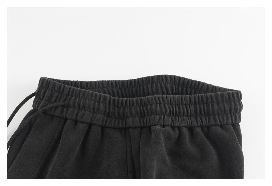 Close-up of black pants showing the gathered elastic waistband and drawstring.