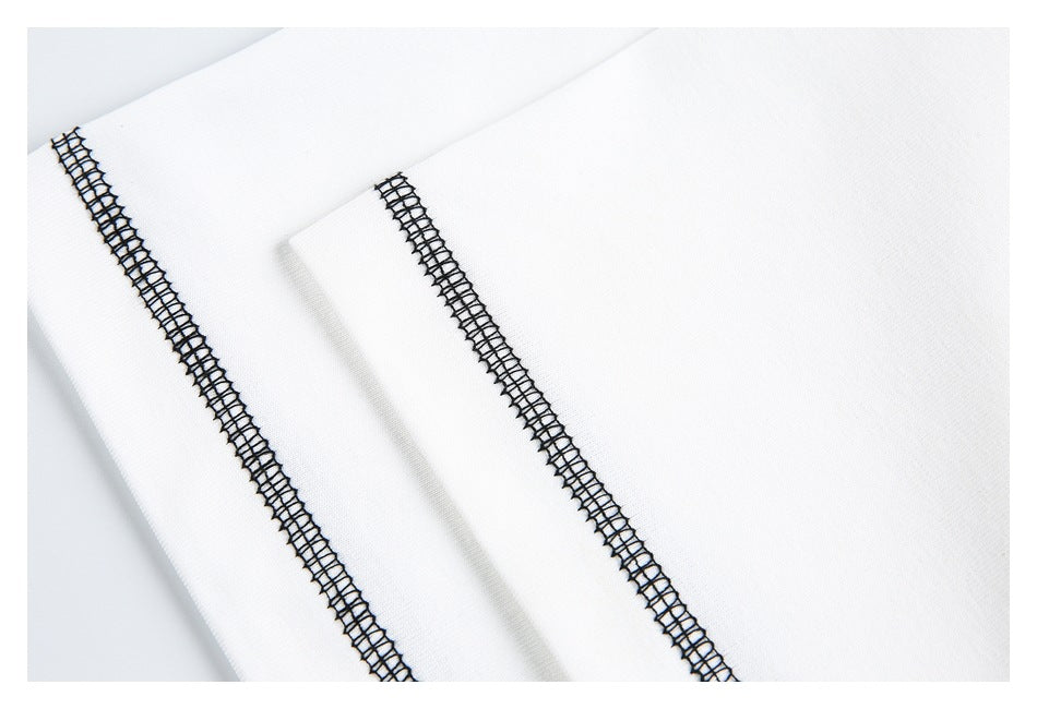 Close-up of white garment panels with two parallel lines of black overlock stitching.