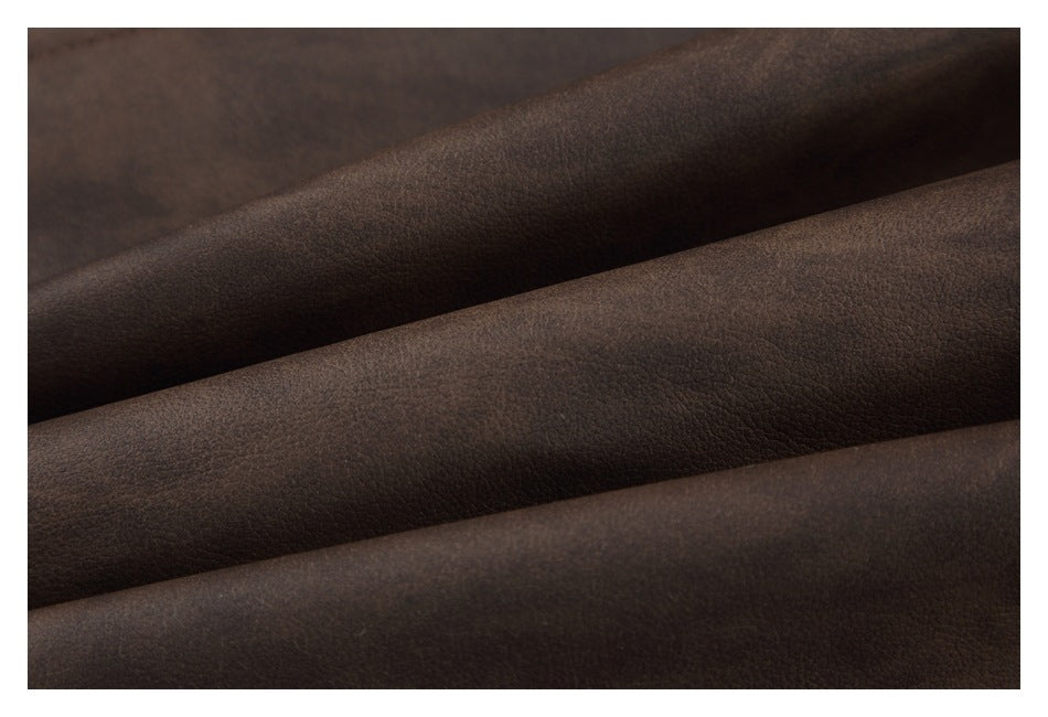Close-up of dark brown pebbled material folded into broad diagonal ridges.