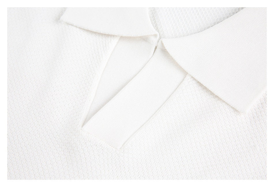 Close-up of a white knit polo shirt's collar and open placket.