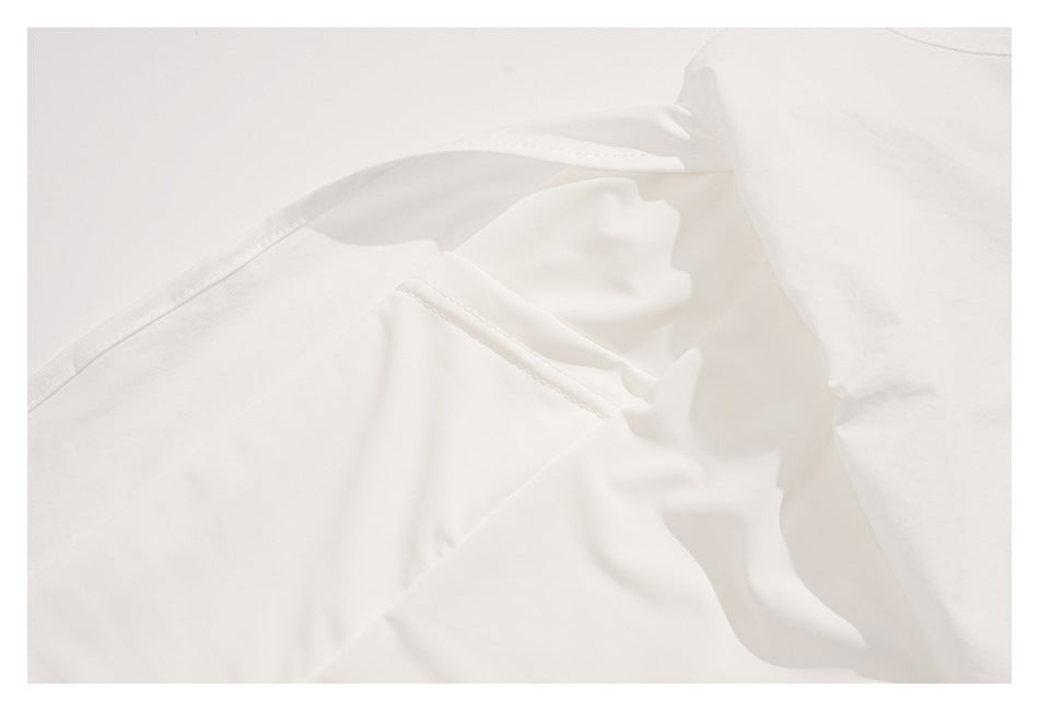 Close-up of white garment construction with intersecting stitched seams and folded fabric.