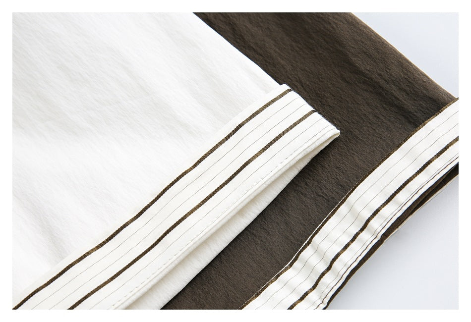 Close-up of striped sleeve cuffs on white and dark brown shirts.