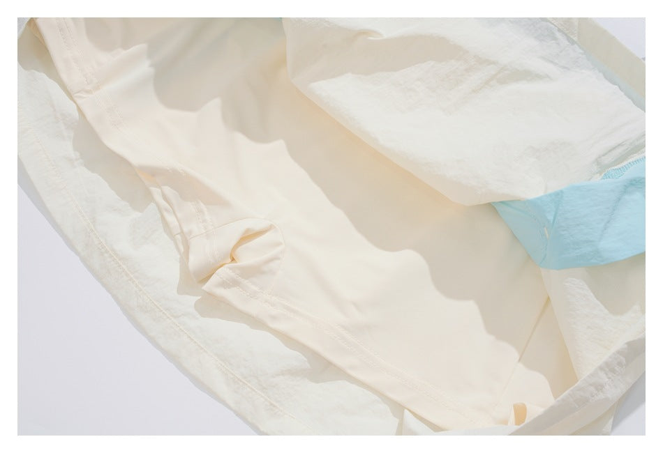 Close-up of the garment's off-white interior layers and stitching, with a light blue section visible.