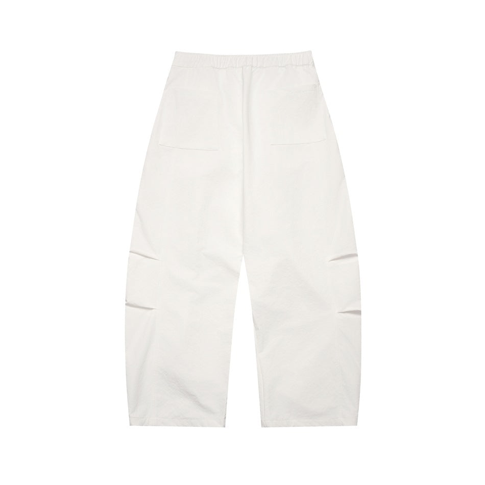 Full view of off-white wide-leg trousers from the back, with two patch pockets and folded details at the knees.