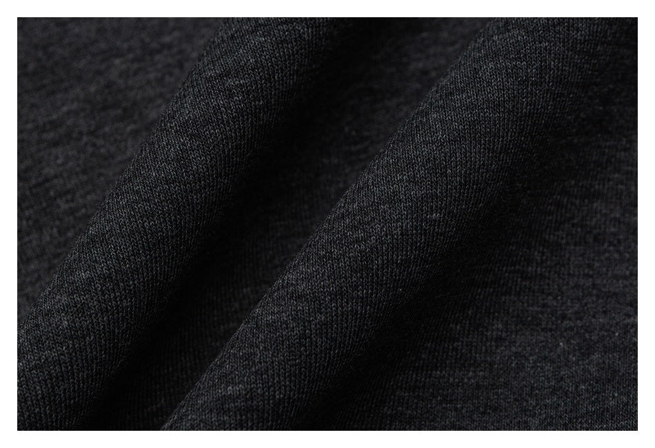 Macro view of the dark charcoal heathered knit texture of the pants fabric.