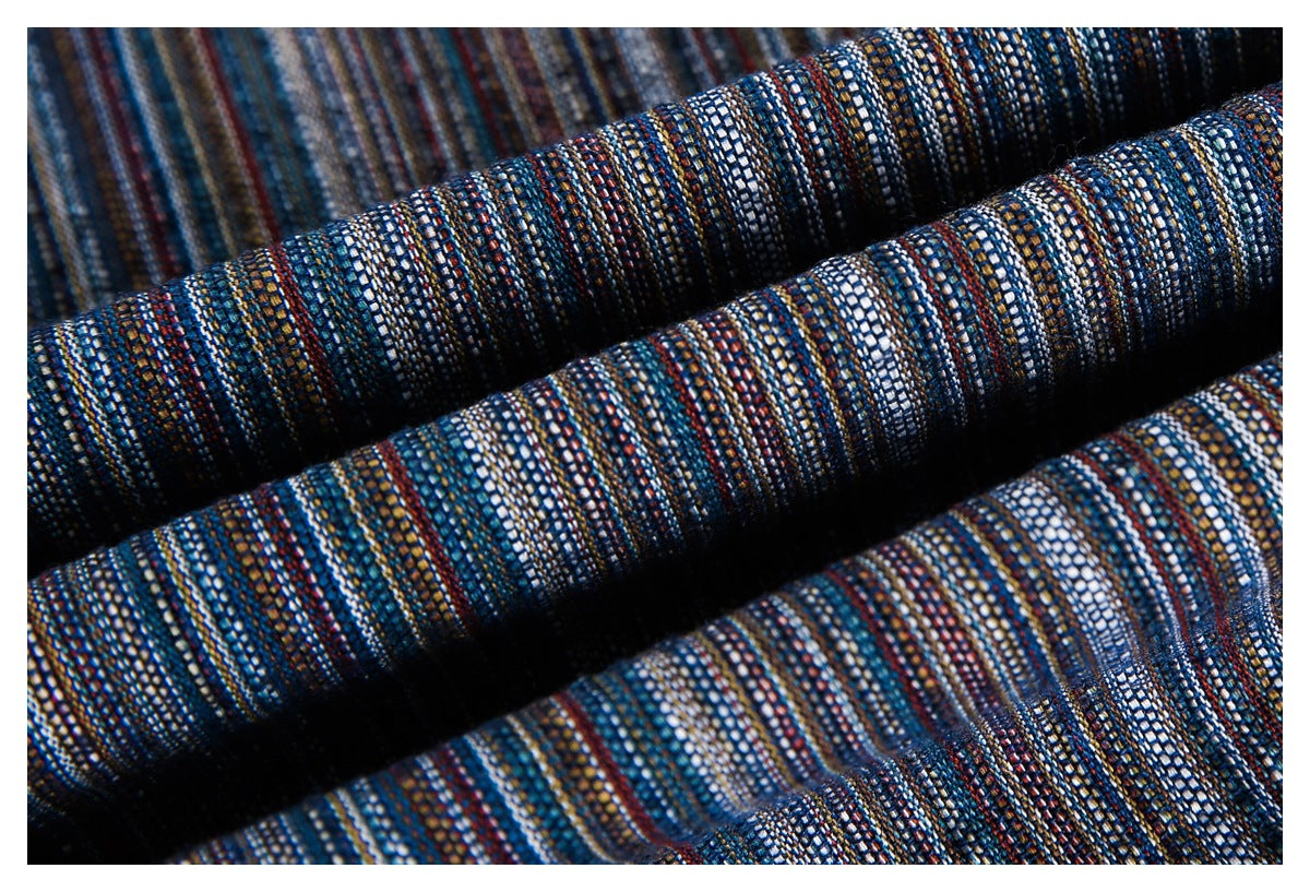 Macro view of folded, fine-striped fabric in blue, white, rust, and tan.