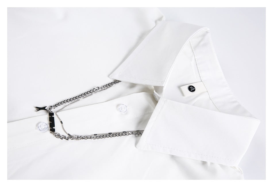 Close-up of a white shirt collar, buttons, and layered silver chain decoration with a star charm.