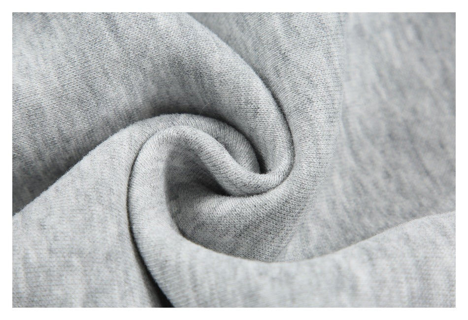 Close-up of light gray knit fabric gathered into a spiral fold.