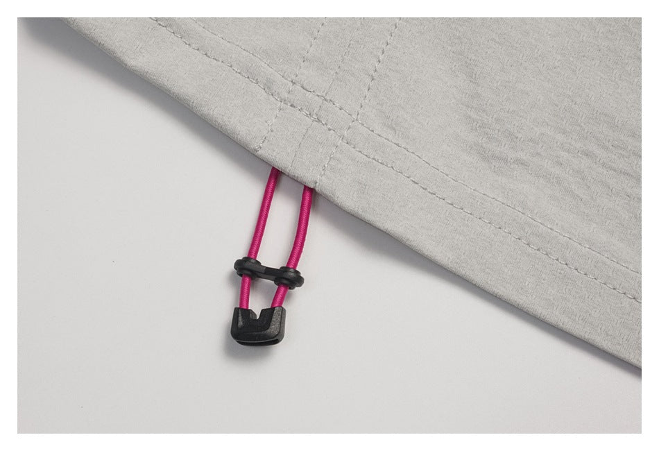 Close-up of the light gray top's hem drawcord with bright pink cords and a black toggle.