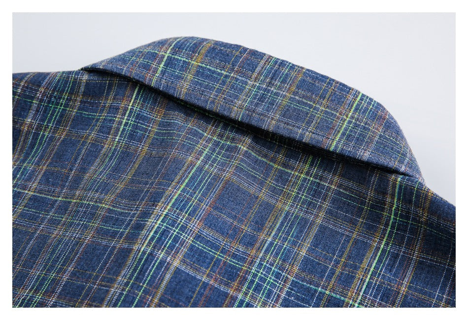 Close-up of the collar on a dark blue plaid garment with green, yellow, and rust-colored lines.