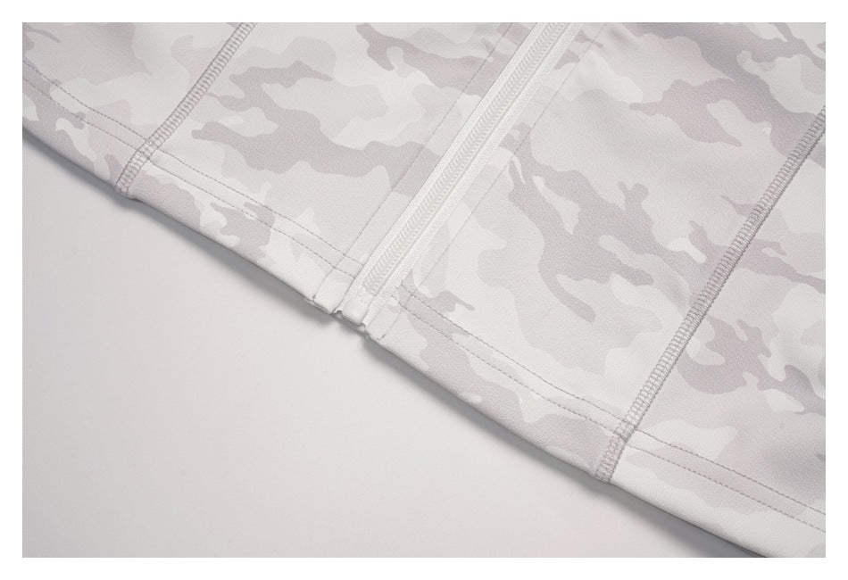 Close-up of the bottom hem, zipper end, and seams on a light gray camouflage top.