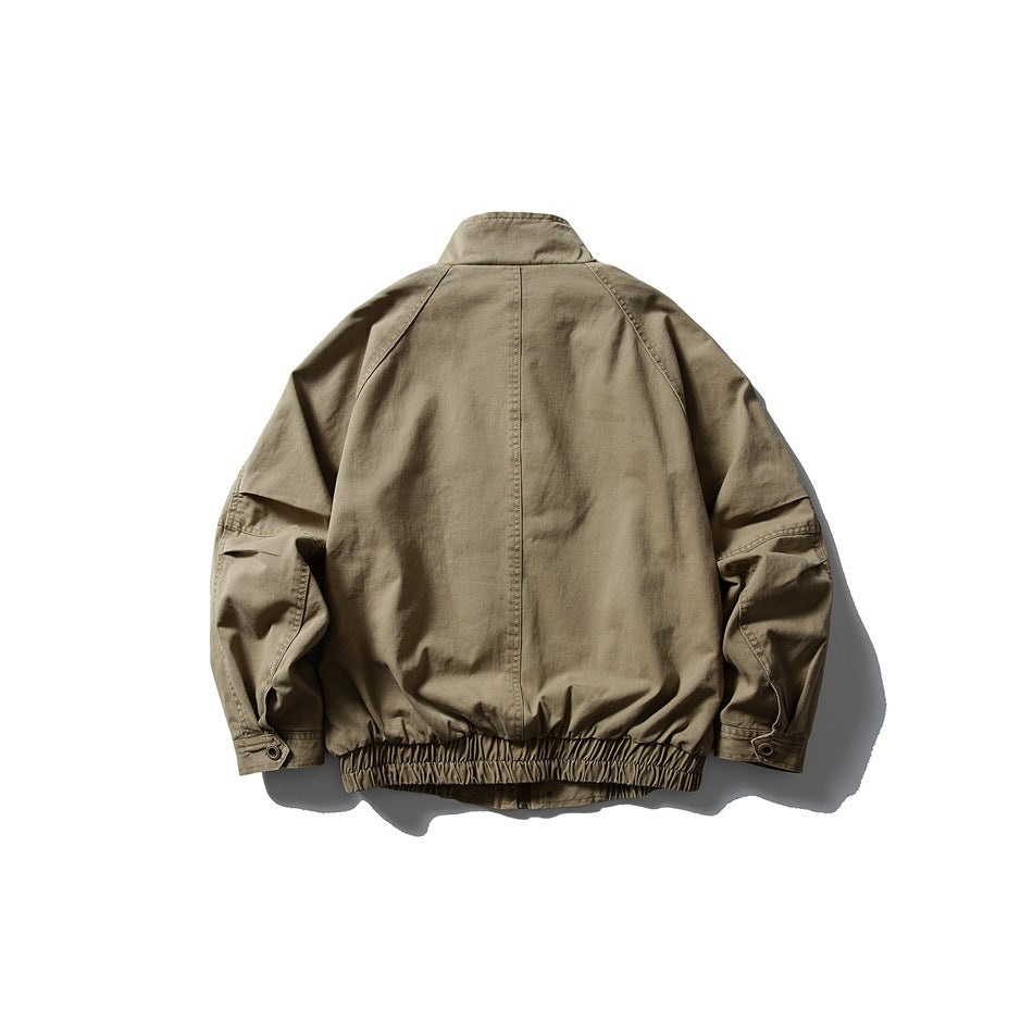 Back view of an olive-khaki jacket with raglan sleeves, buttoned cuffs and a gathered elastic hem.