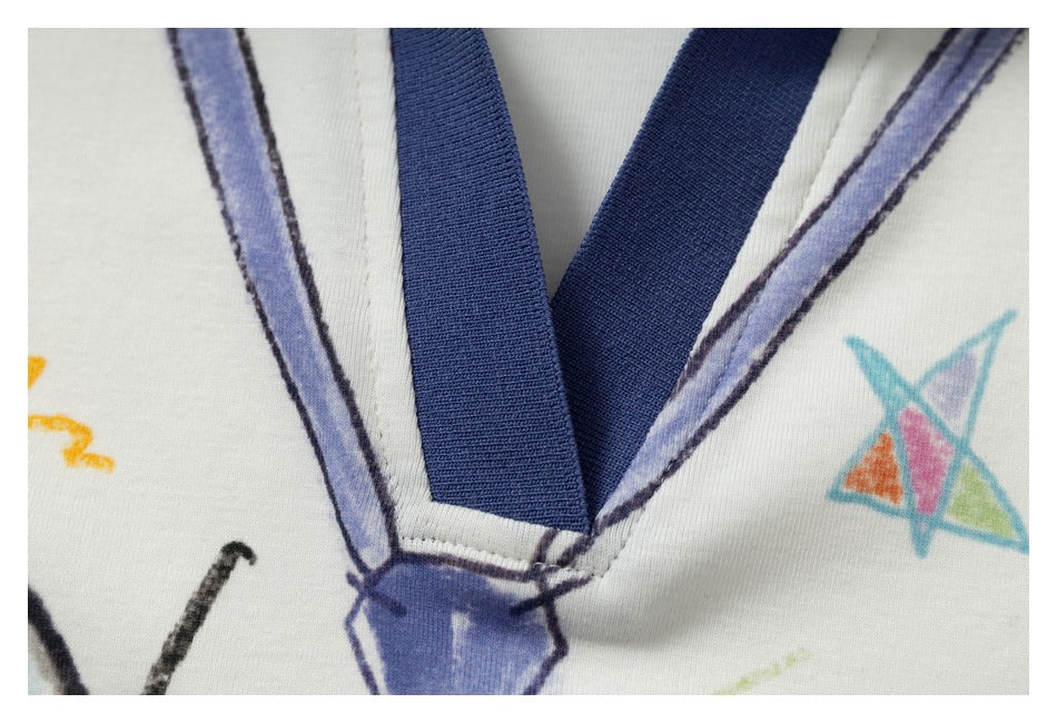 Close-up of the polo's blue V-neck trim and placket stitching against ivory fabric with colorful print.
