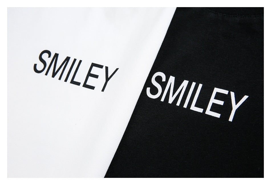 Close-up of white and black T-shirt fabric, each printed with the word “SMILEY.”