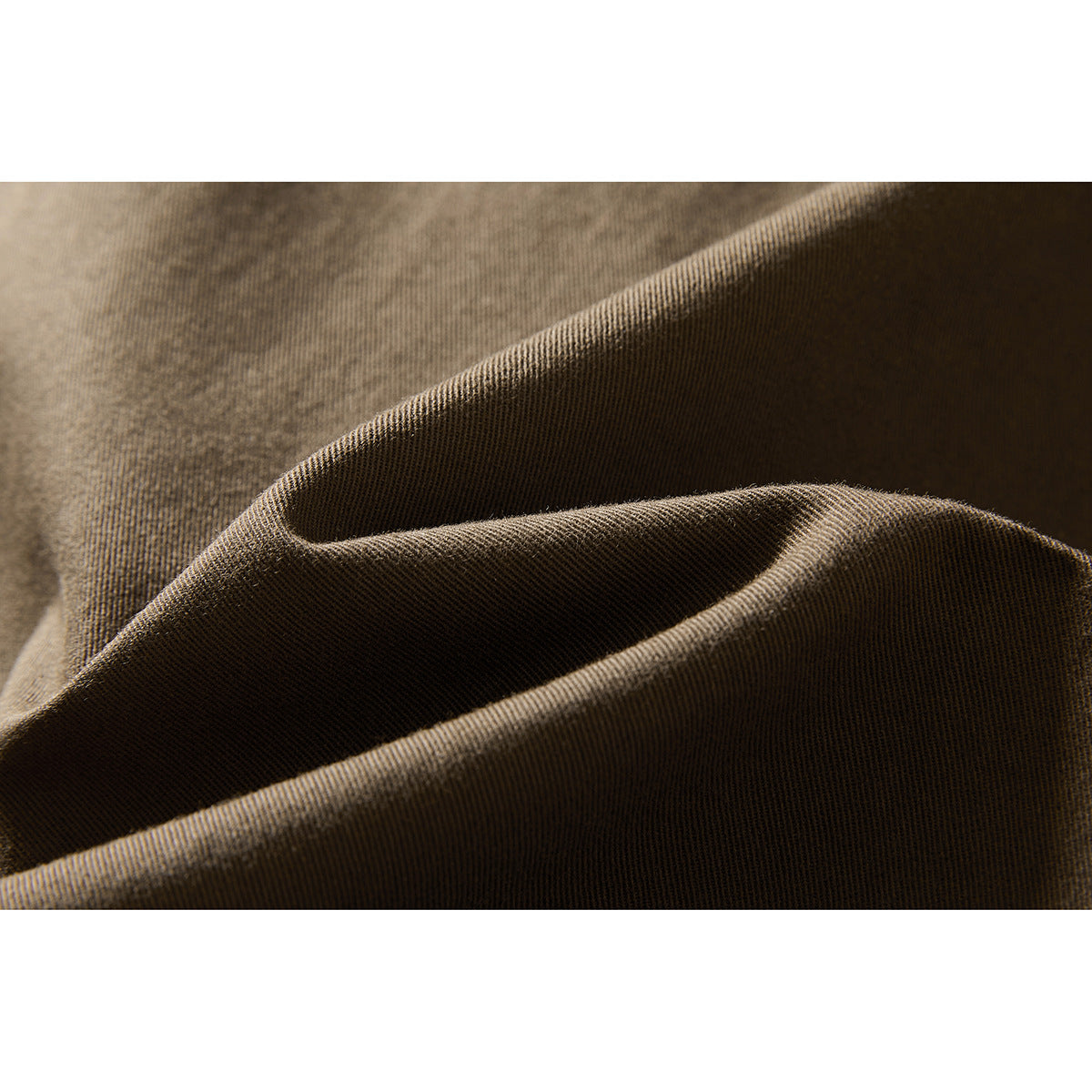 Extreme close-up of brown woven fabric folded to show its surface and texture.