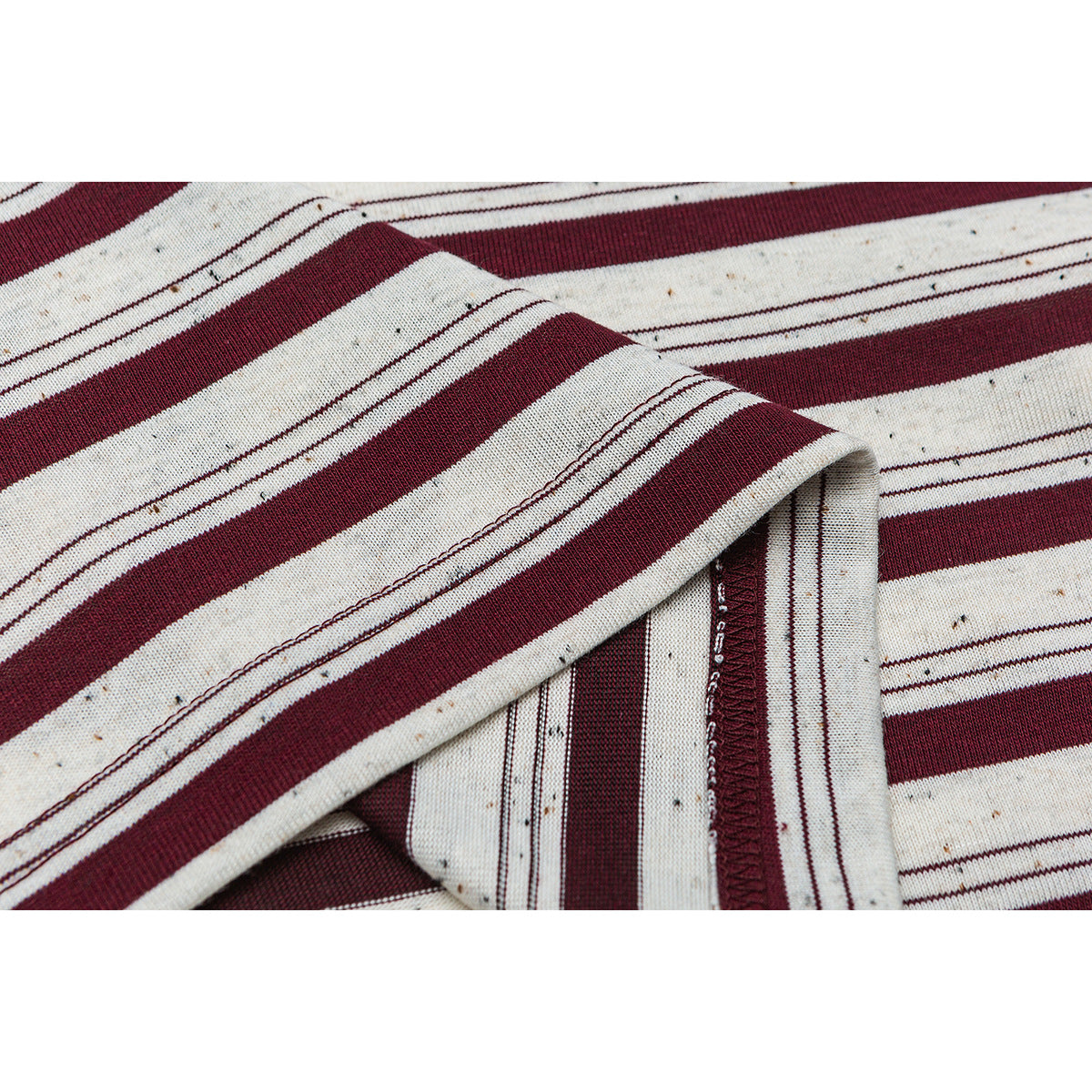 Close-up of cream fabric with burgundy stripes and a folded, stitched hem.