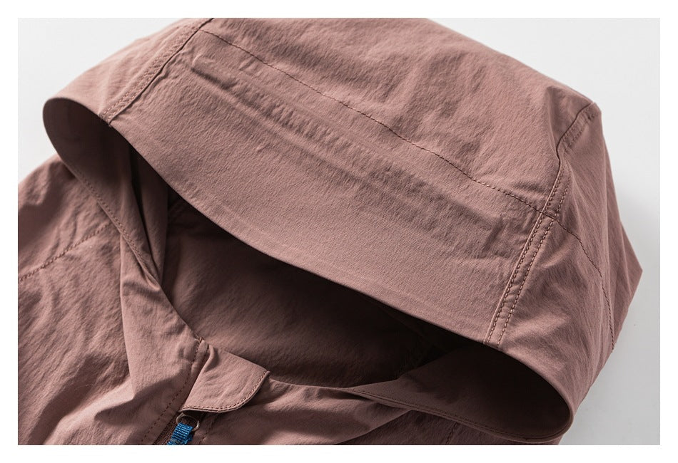 Close-up of a dusty mauve jacket hood, showing its panel seams and a small section of blue drawcord.