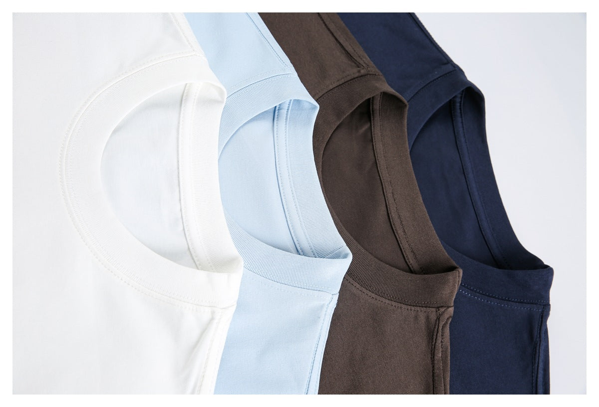 Close-up of four overlapping T-shirts in white, pale blue, brown, and navy, showing their crew necklines.