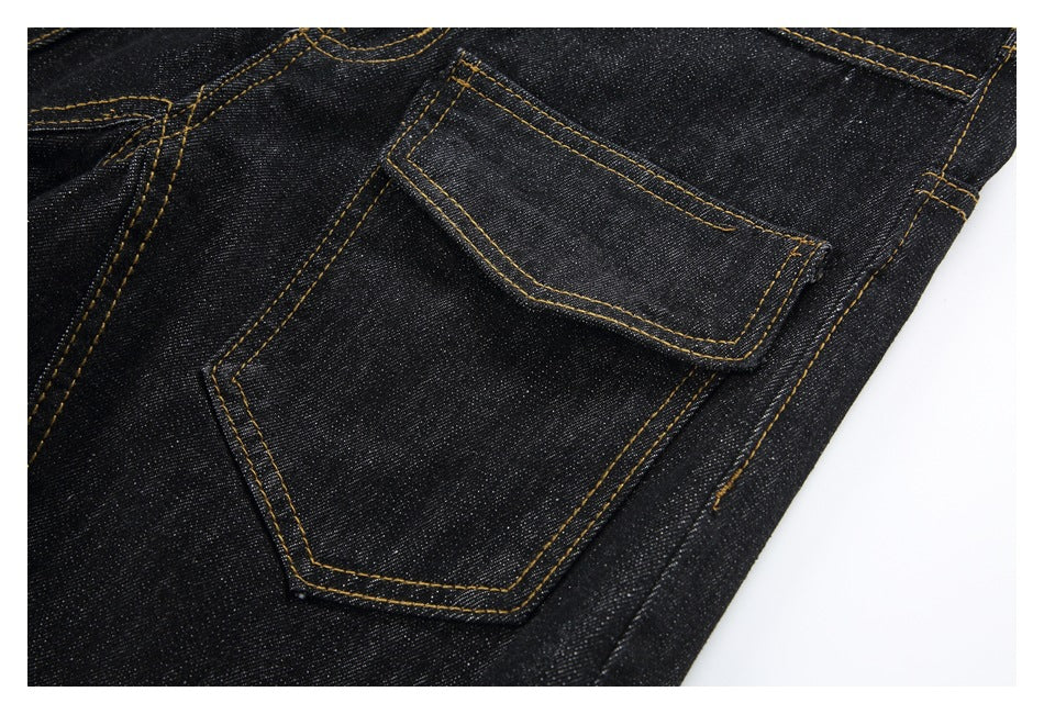 Close-up of a black denim back pocket with contrasting golden stitching.