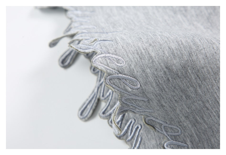 Close-up of gray knit fabric with a decorative looped, scalloped edge.