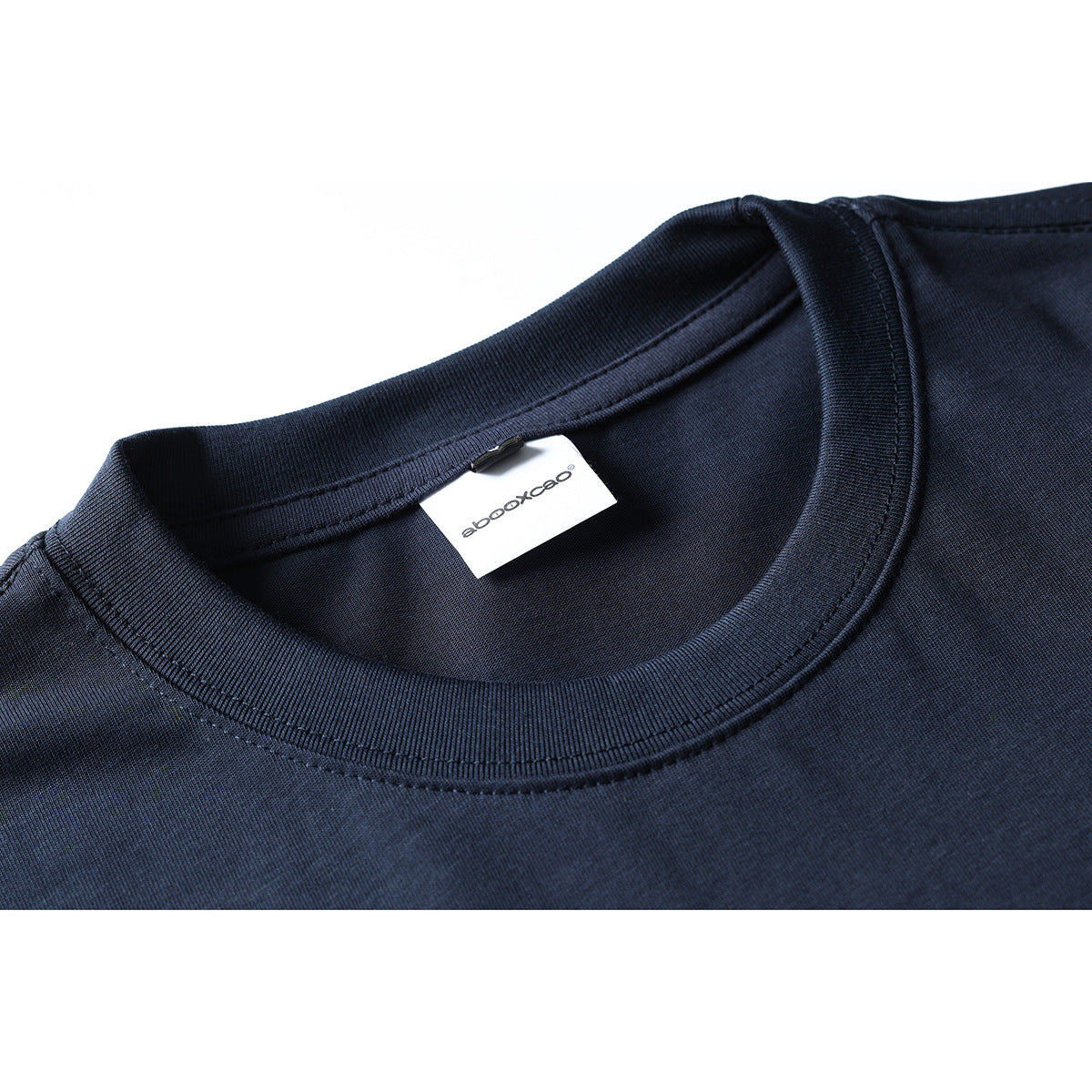 Close-up of a dark navy T-shirt crew neck and ribbed collar with a small white neck label.
