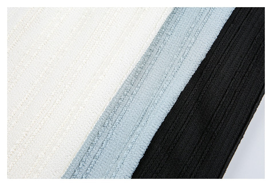 Close-up of textured knit fabric shown in white, pale blue, and black colorways.