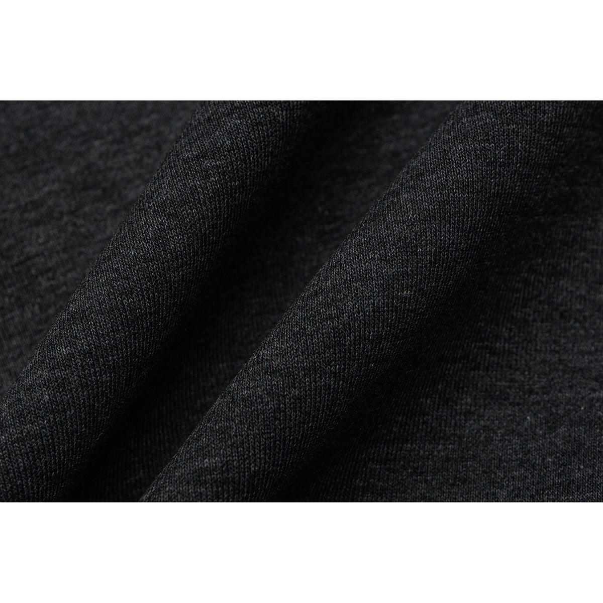 Extreme close-up of dark charcoal knit fabric draped in soft folds.