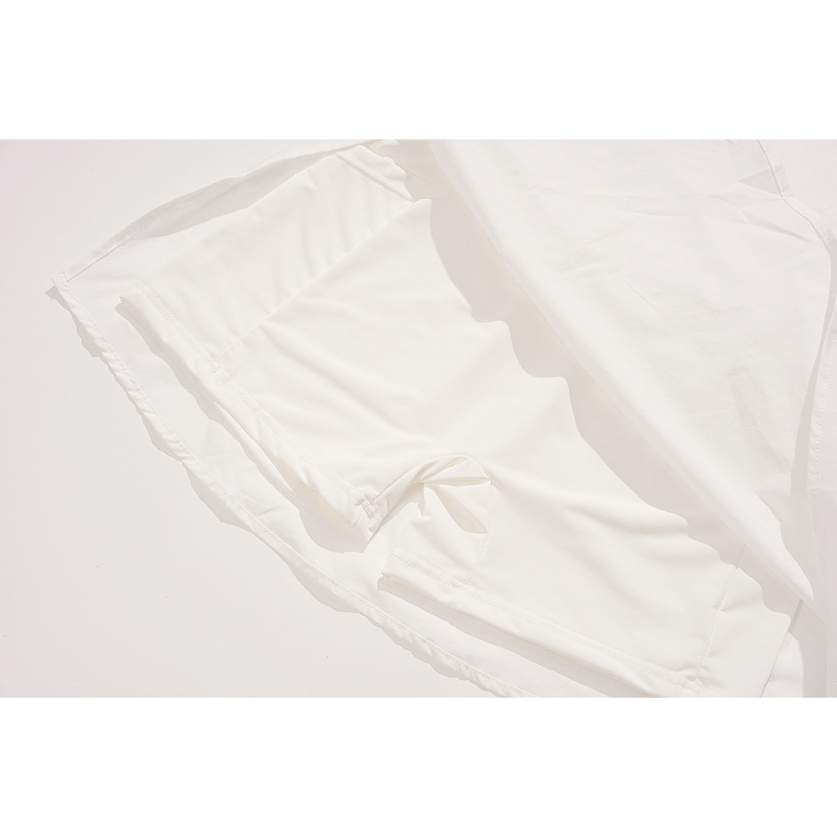 Close-up of the inside of a white skirt, showing layered fabric and stitched seams.