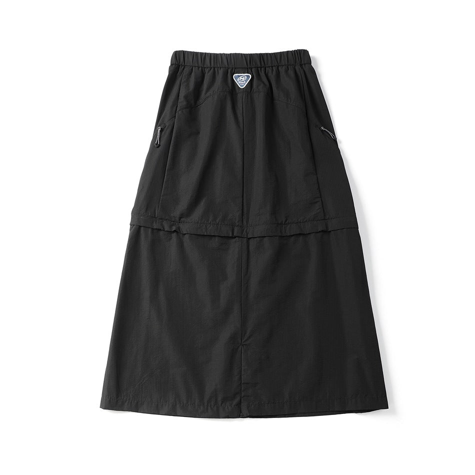 Back view of a black long skirt with an elastic waistband, side zip pockets, and a small label at the waist.
