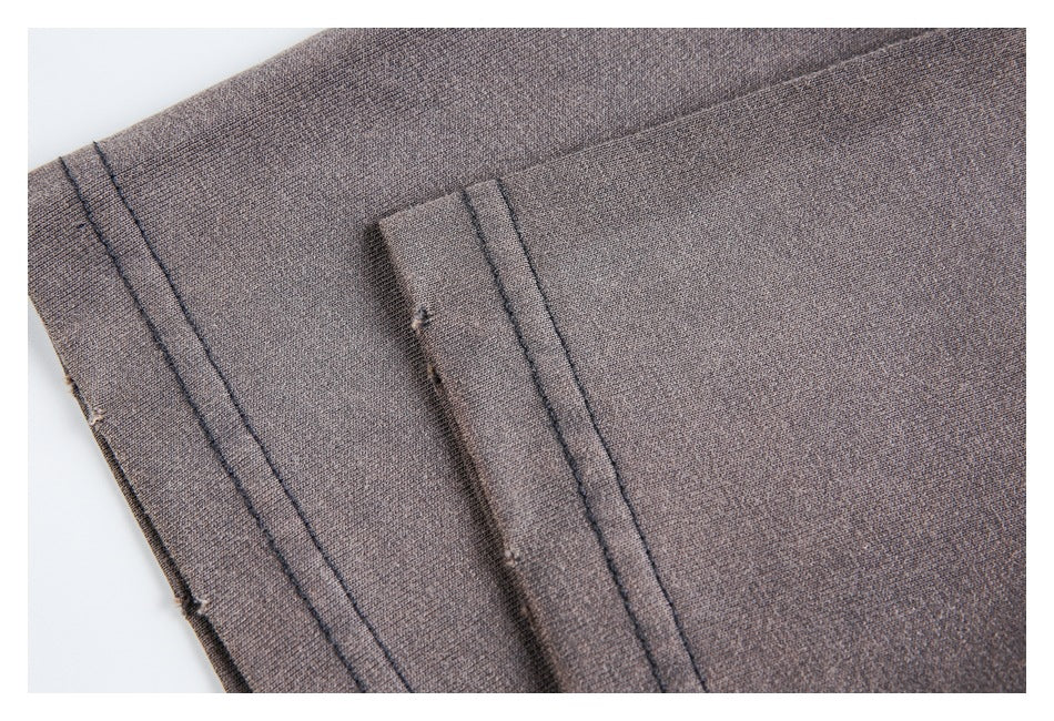 Close-up of folded charcoal-brown garment fabric with stitched edges.
