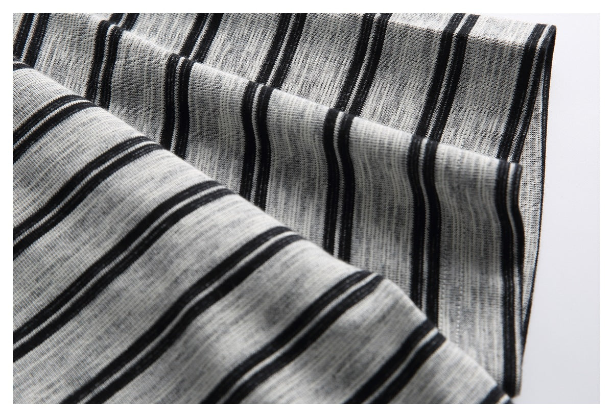 Close-up of folded gray shirt fabric with black stripes, framed by a thin border.