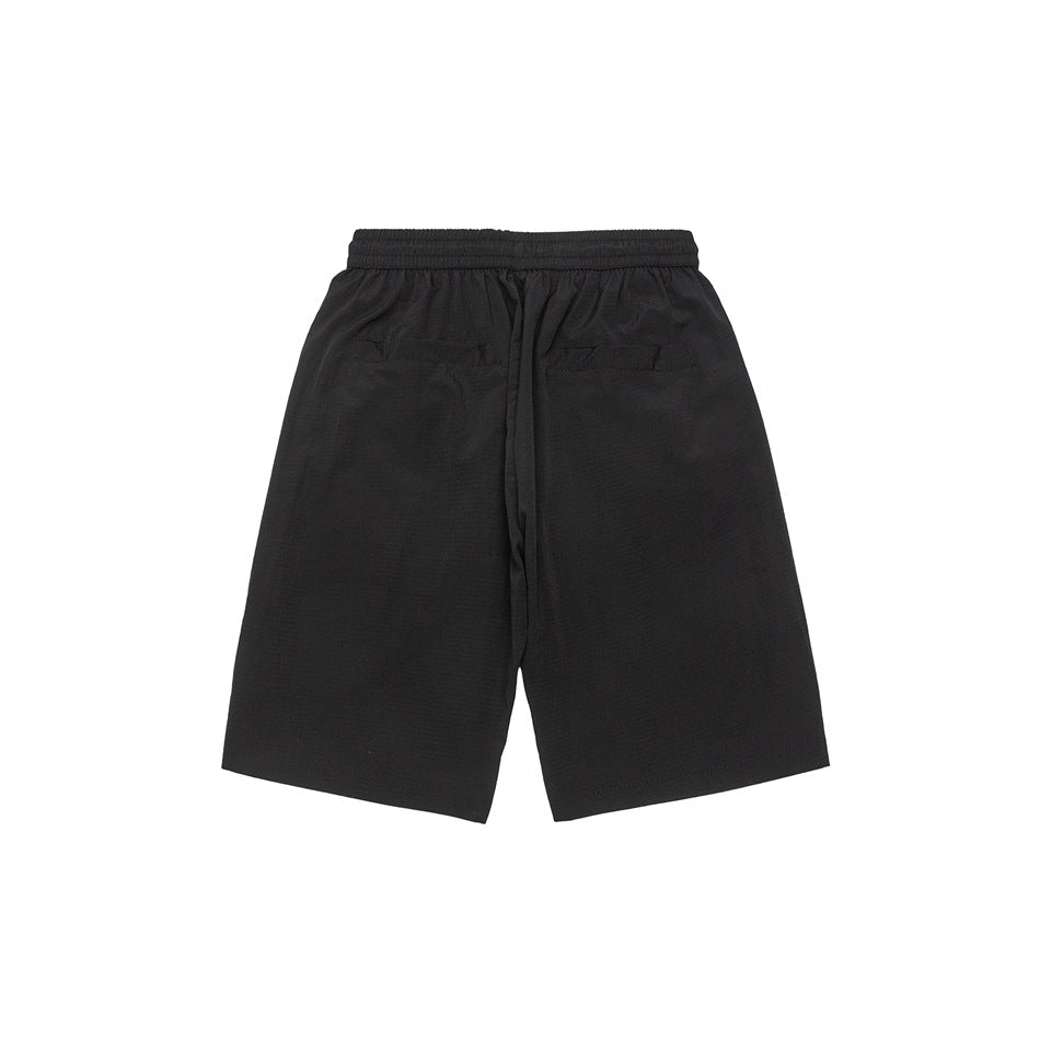 Back view of black loose shorts with an elastic waistband, center drawstring, and two rear pockets.