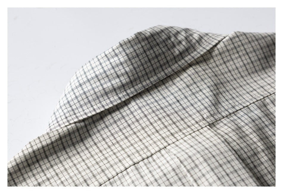 Close-up of folded checked fabric showing a seam and layered edge.