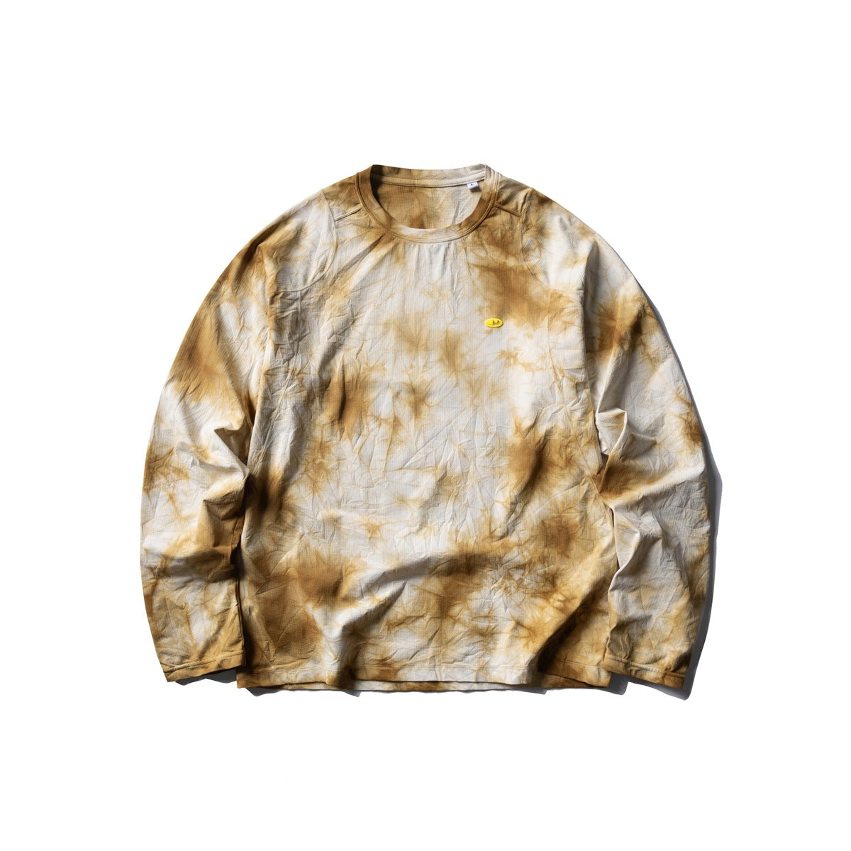 Mustard yellow tie-dye long-sleeve crew-neck top flat lay with a small yellow oval chest patch