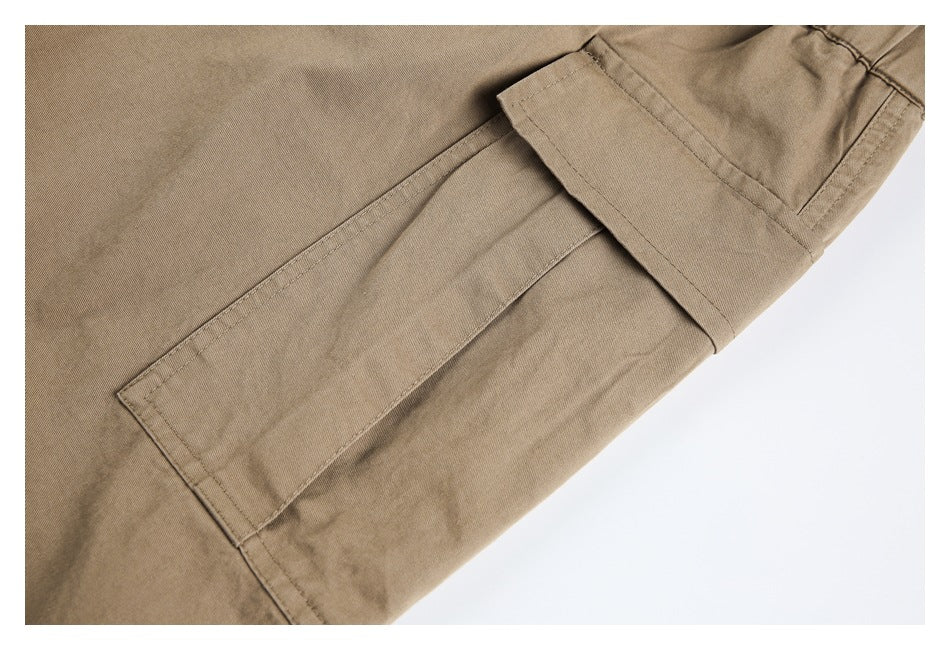 Close-up of a khaki cargo pants leg with a large flap pocket.