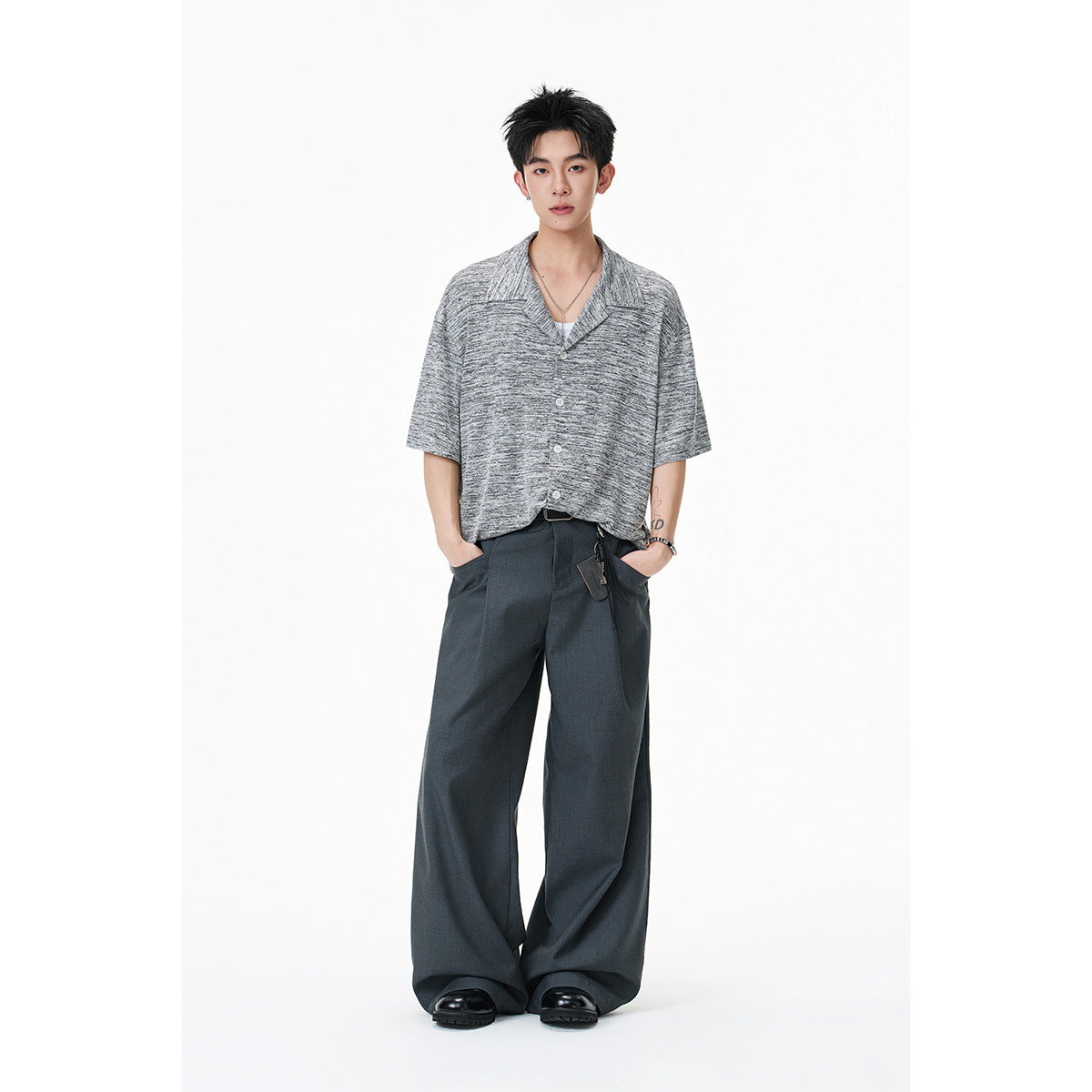 Full-length view of a model wearing a gray marled short-sleeve button-front shirt with a notched collar.