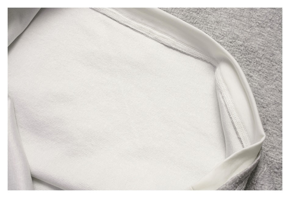 Close-up of the white inner layer and overlocked seam inside the gray sweatshirt.