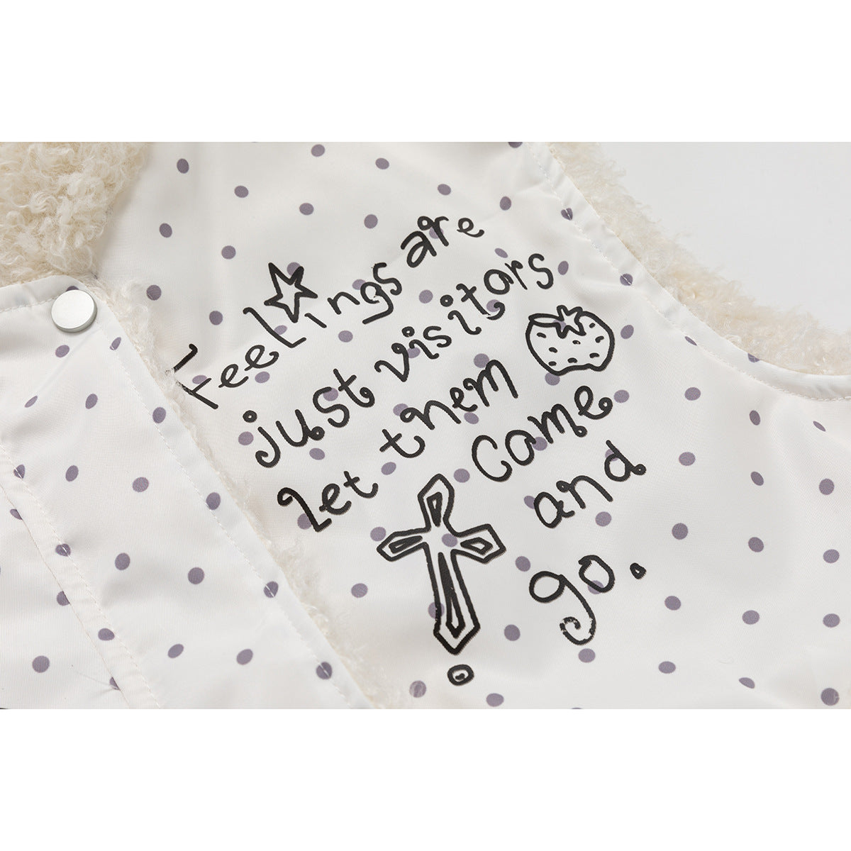 Close-up of a white, gray-dotted vest lining with the printed English phrase “Feelings are just visitors. Let them come and