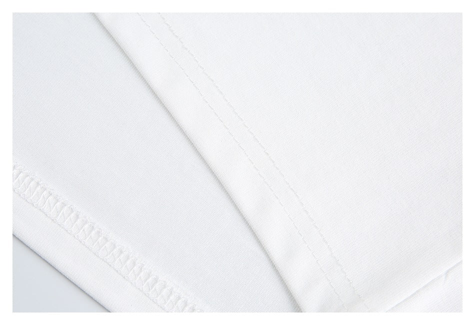 Close-up of white garment fabric with a curved seam and overlocked edge stitching.