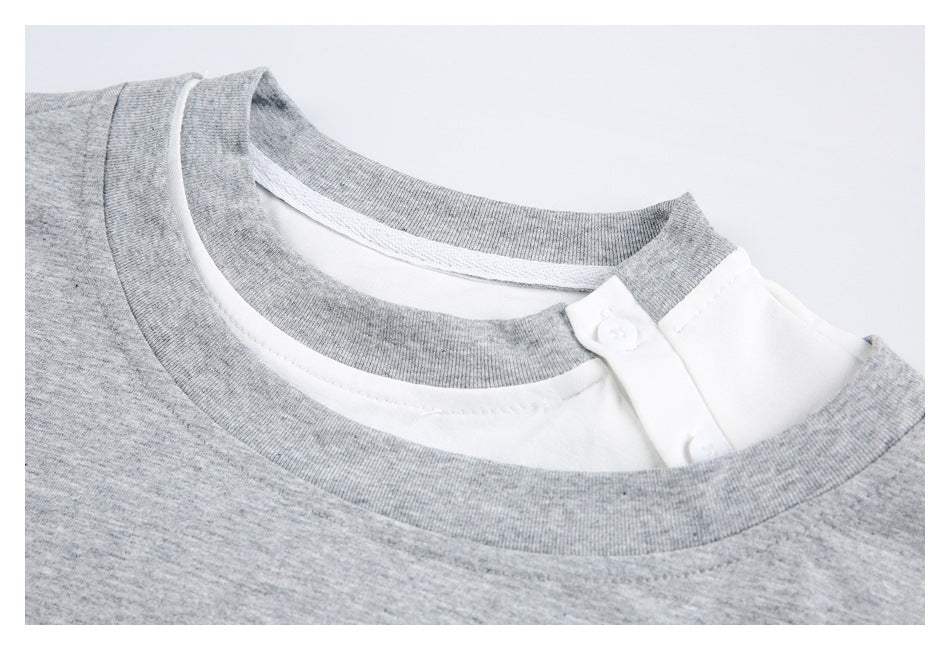 Close-up of the gray T-shirt's layered crew neckline and white buttoned inner placket.