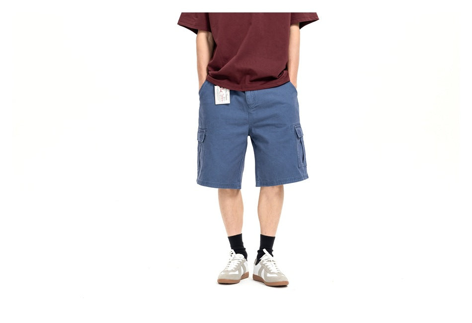 Model wearing blue cargo shorts with flap side pockets; cropped front view against a white background.