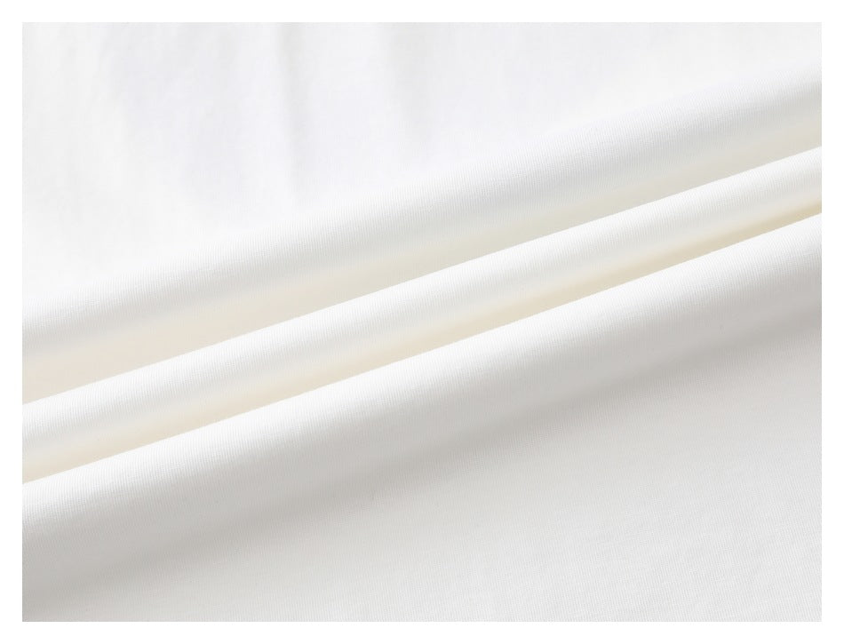Close-up of white garment fabric draped in soft folds.