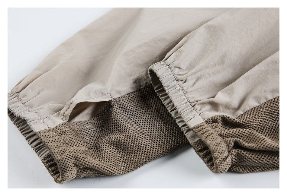 Close-up of beige garment fabric with gathered elastic edges and a brown open-mesh panel.