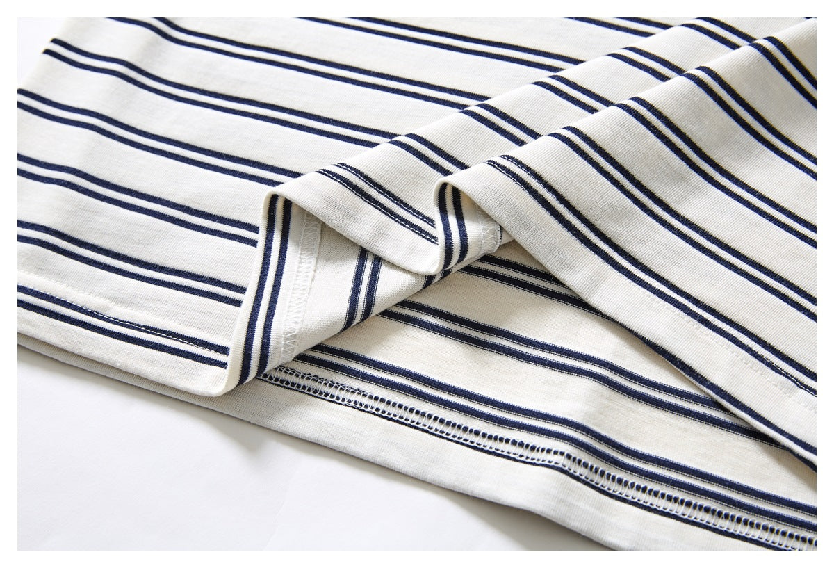 Close-up of the inside overlock stitching and folded hem on a navy-striped ivory garment.