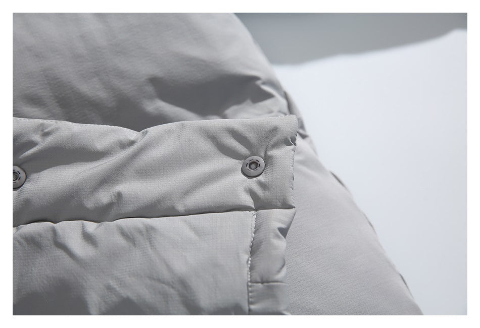 Close-up of a light gray jacket flap with two gray snap buttons.